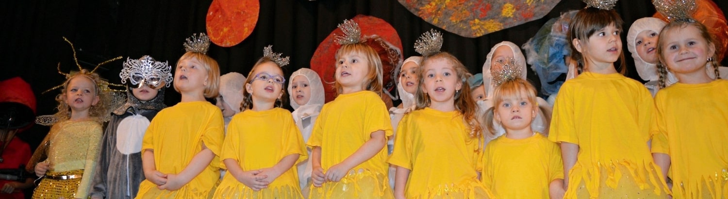 Děti zpívají na pódiu v kostýmech